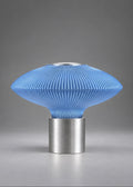 COSMOS futuristic designer table lamp featuring a translucent blue PETG diffuser with custom 3D printed texture and a brushed aluminium base, inspired by space objects and orbital forms.